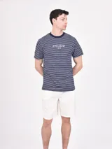 Remera de hombre a rayas horizontales azul marino y blancas con cuello redondo y logo estampado en el pecho.