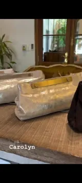 Sobre de fiesta color dorado con textura brillante y cierre con barra metálica dorada.