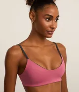 Top deportivo reversible en microfibra doble faz, color rosa con tiras grises. Tiene escote en V, breteles finos paralelos y copas removibles.