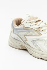 Zapatillas urbanas blancas con detalles plateados, de caña baja y cordones.