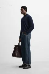 Polo de hombre color gris oscuro, de punto ligero tejido en hilatura con mezcla de seda y algodón. Tiene cuello solapa con cierre frontal de botonadura, manga larga y acabados en rib.