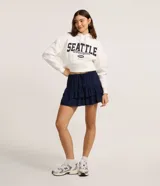 Short pollera de viscosa color azul marino, con cintura elástica y lazo ajustable, con diseño de volados superpuestos.