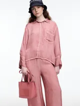 Camisa gris de manga larga confeccionada en viscosa teñida en frío, con efecto gastado. De corte relajado, con bolsillo delantero y puños amplios.