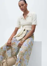 Pantalón largo de gasa con estampado floral en tonos verde, celeste y marrón. Diseño balloon con detalle de lazos en el bajo y tiro medio.