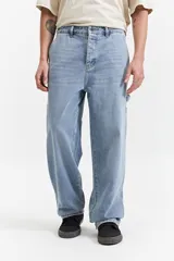 Pantalón jean celeste de corte carpenter, tiro medio, con presillas para cinturón y bolsillos laterales.