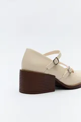 Zuecos estilo Mary Jane color borgoña charol con doble tira con hebillas metálicas plateadas, punta redondeada y taco ancho negro.