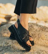 Sandalias de cuero vacuno color marrón, con tiras anchas cruzadas en el empeine, elástico en el talón y doble suela de goma deportiva.