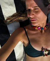 Conjunto de bikini rojo con corpiño triangular con abertura central y detalle de cuentas de colores.