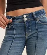 Pantalón bootcut de jeans azul con bolsillos delanteros y traseros, cierre con botón y cremallera, y nervaduras verticales en la parte delantera.