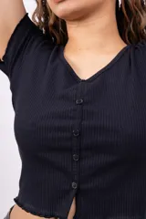 Remera corta de punto canalé color rosa, con escote en V, mangas cortas con volados y cierre frontal con botones.