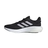 Championes de running Adidas Supernova 3, color negro con detalles en blanco. Presentan una parte superior de malla transpirable, acolchado en la lengüeta y el talón, mediasuela con amortiguación Bounce y Boost, y suela de goma.