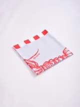 Pareo rectangular con estampado de flores rojas y blancas.
