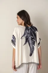 Blusa italiana color natural con estampado de hojas en tonos azules. De calce holgado y talle único.