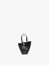 Bolso Jacquemus Le Petit tipo cubo, color negro, de cuero liso, con asa corta y cierre de anilla dorada. Incluye correa bandolera extraíble, bolsillo interior con cremallera y herrajes dorados.