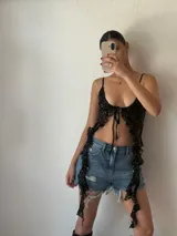 Top negro de lentejuelas con breteles finos y lazo ajustable en el centro del busto.