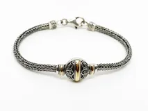 Pulsera de plata 925 con detalles en oro 18k y diseño circular central combinado.
