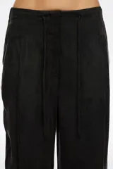 Pantalón ancho de tiro alto, color negro, con pinzas frontales y cordón ajustable en la cintura.