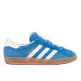 Championes Adidas Gazelle Indoor color celeste con detalles en blanco y suela marrón.