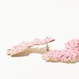 Par de caravanas con forma de flor, color rosa con lunares rojos y borde dorado.