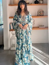 Vestido largo de polysilk con estampado paisley en tonos azul, celeste y dorado. Tiene escote en V, mangas largas acampanadas y corte amplio.