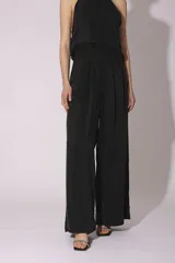 Conjunto de pantalón y top de seda color gris, con cuello halter y corte holgado.