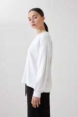 Sweatshirt blanco de manga larga con cuello redondo y puños elásticos.