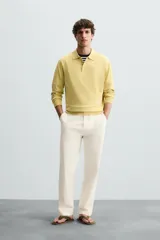 Pantalón chino color crema, de corte recto y largo a la altura del tobillo.