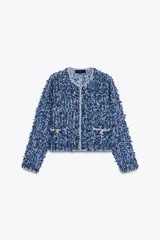 Chaqueta corta azul con tejido de punto entrelazado, cuello redondo, manga larga, bolsillos delanteros de plastrón y cierre frontal con botones dorados.
