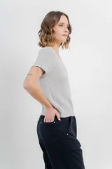 Remera tejida de manga corta, color gris claro, con escote en V y calce relajado. Presenta terminaciones acanaladas en mangas y ruedo.