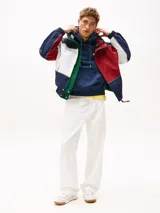 Campera náutica amplia reversible de nailon, con diseño color block en rojo, blanco y azul marino. Tiene capucha fija, cierre de cremallera oculto con botones a presión, puños y bajo elásticos, dos bolsillos ribeteados en la cintura, parche con logo de Tommy Hilfiger en el pecho y logo de Tommy Hilfiger en el cuello, las mangas y la espalda.