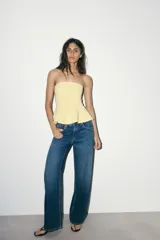 Top palabra de honor blanco con hombros descubiertos, corte ajustado y bajo con peplum.