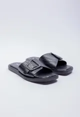 Sandalia de símil cuero negro con tira ancha y hebilla decorativa sobre el empeine.