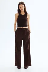 Pantalón marrón de algodón, corte holgado, tiro alto, cintura elástica fruncida con cordón ajustable, piernas anchas y bolsillos laterales.