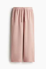 Pantalón deportivo rosa de corte ancho, con cintura elástica ajustable con cordón y bolsillos laterales.