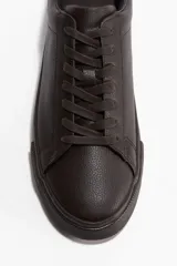 Championes deportivos color marrón oscuro, con collarín y lengüeta acolchados, cierre de cordones y suelas de goma con diseño texturizado.