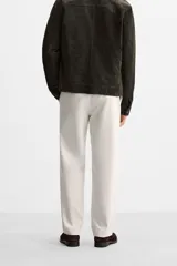 Pantalón de vestir color crema, de corte recto, con bolsillos laterales y traseros de ojal con botón.