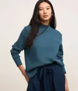 Sweater negro de punto con cuello redondo, puños y ruedo acanalados. Incluye cuello, puños y ruedo de camisa celeste a rayas.