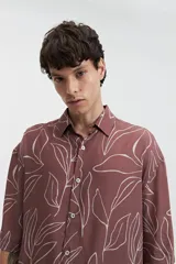 Camisa oversize de manga corta con estampado abstracto en tonos beige y blanco.