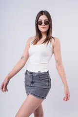 Minifalda de jean color gris oscuro desgastado, tiro medio/bajo, con cierre y botón frontal.