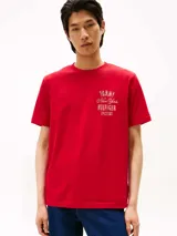Remera roja de algodón con cuello redondo y manga corta. Estampado frontal con el logo de Tommy Hilfiger en color dorado.