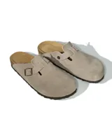 Zuecos de cuero gamuzado color gris con diseño de punta cerrada y correa ajustable con hebilla metálica. Poseen plantilla anatómica de corcho y suela de goma.