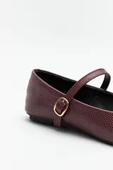 Balerinas color borgoña de cuero sintético texturizado, con tira sobre el empeine y hebilla metálica ajustable.