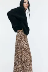 Pollera midi de malla plisada con estampado de leopardo, corte evasé, elástico en la cintura y forro de punto.