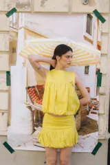 Top musculosa de lino color rojo, con cuello redondo y diseño estilo balloon con volumen en el ruedo. Cuenta con cierre de botones en la parte trasera.