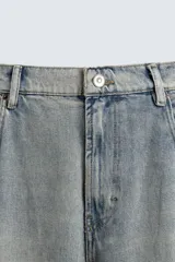 Pantalón de jean celeste con efecto lavado, corte amplio tipo balloon fit, tiro medio, cinco bolsillos y cierre frontal con cremallera y botón.