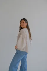 Camisa beige de lino con bordado de flores, cuello mao con volados y mangas largas abullonadas.