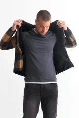 Campera con capucha para hombre, con cierre frontal y bolsillos laterales. Diseño a cuadros grandes en tonos verde y negro.