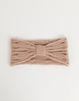 Vincha color beige de tejido de punto trenzado con detalle de lazo en el centro.
