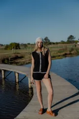 Conjunto tejido de algodón color celeste con terminaciones en marrón. Incluye un top sin mangas con botones y un short de tiro alto.