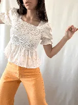 Blusa de manga corta con diseño fruncido y estampado floral en colores suaves.